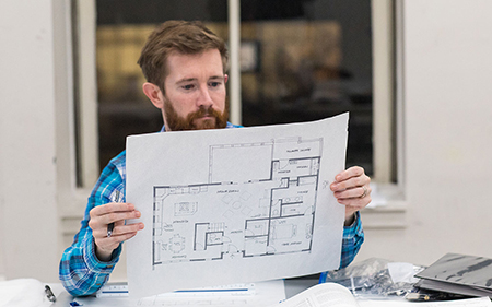 A student holding a drafted floor plan.